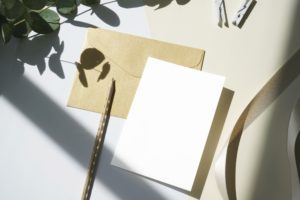 Photo of a blank postcard and a pen.